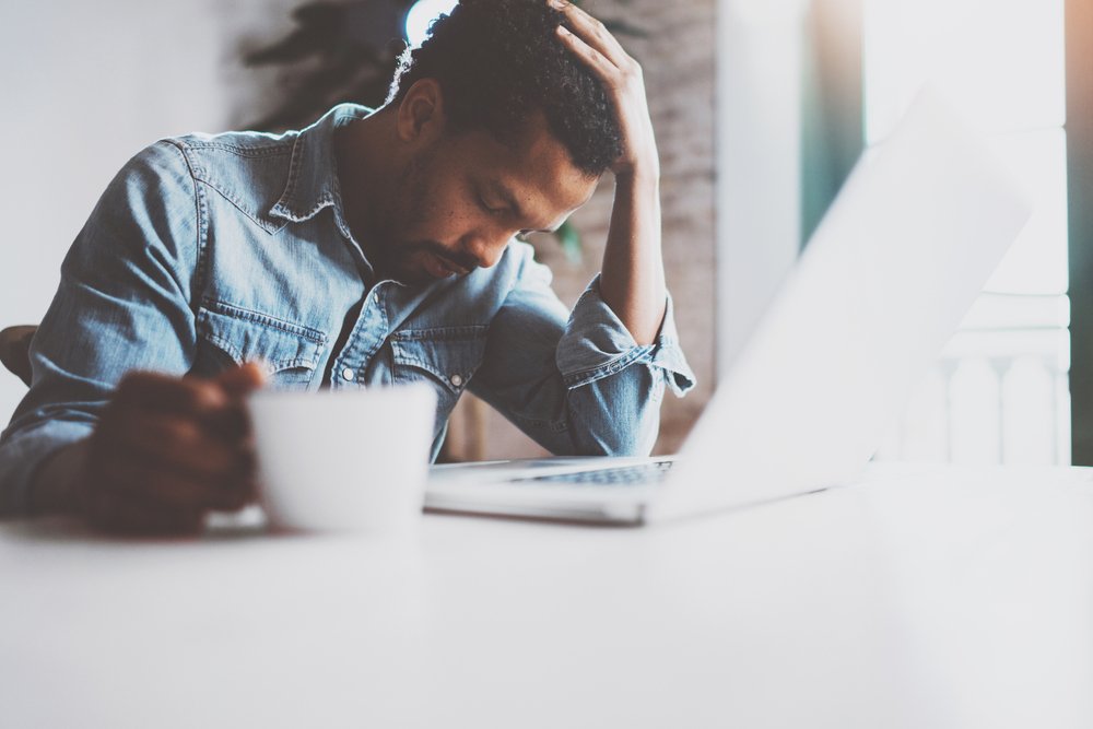 man using laptop while sitting at the table