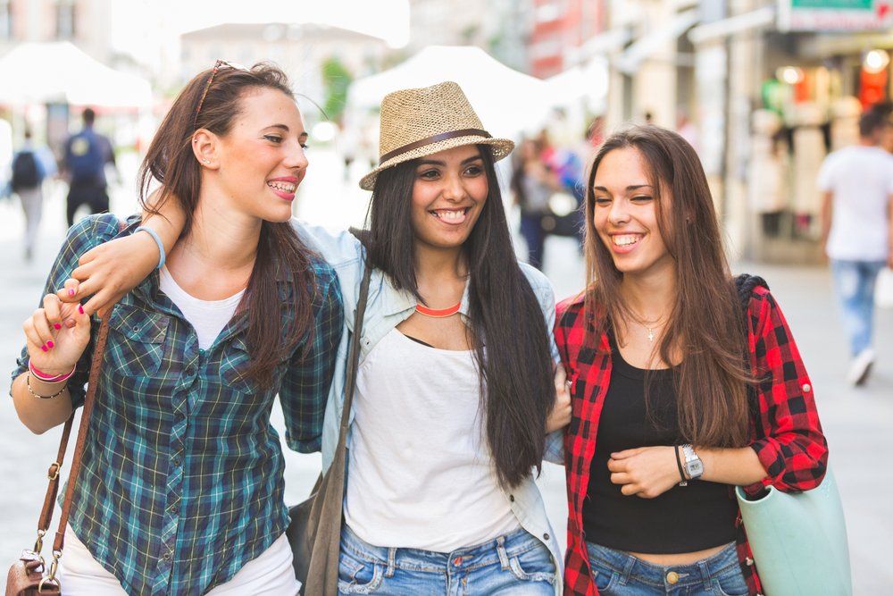 Three happy women walking in the city