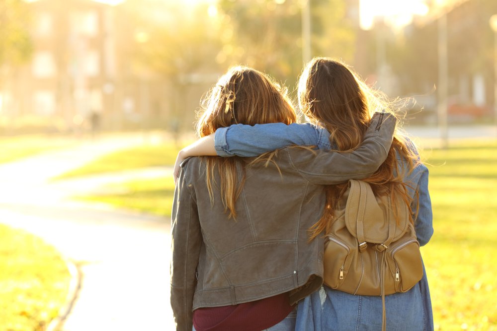 friends walking at sunset in a park