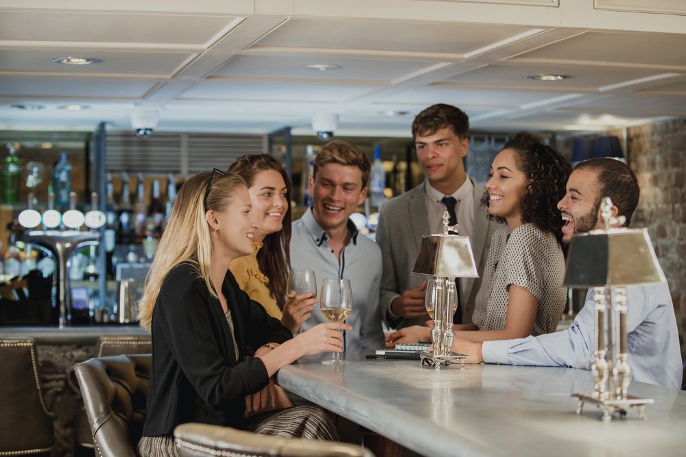coworkers are enjoying drinks in a bar after work