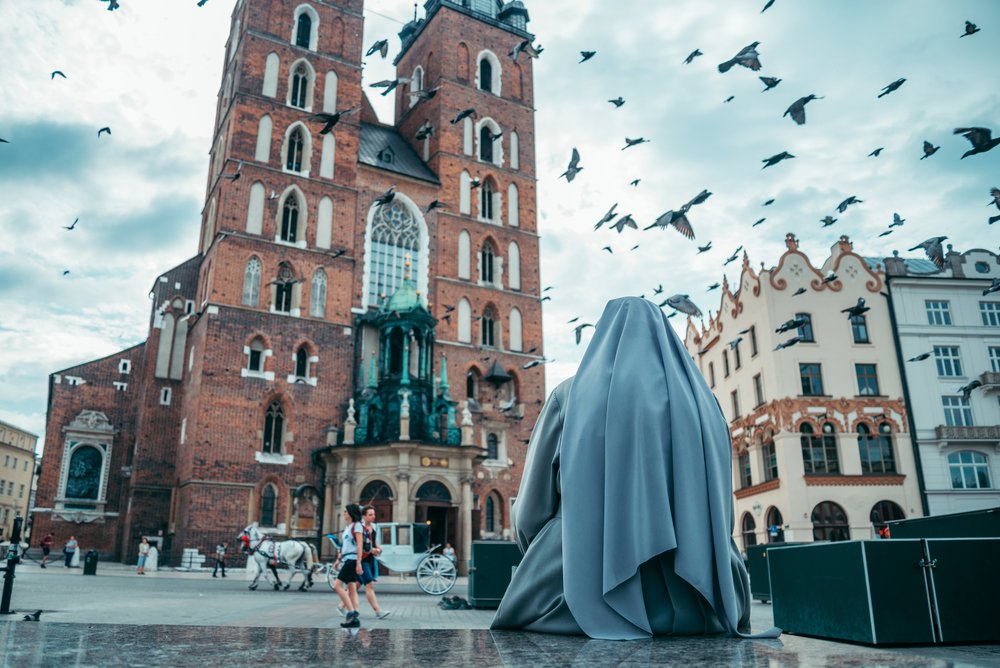 nun looking on old church
