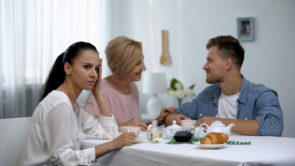 Mother-in-law and son talking and ignoring